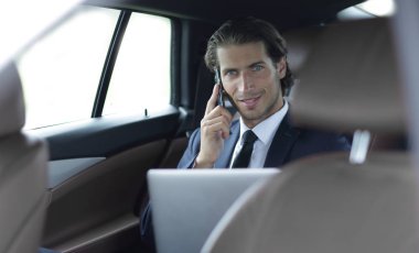 Yakışıklı işadamı cep telefonu arabaya kullaranarak.