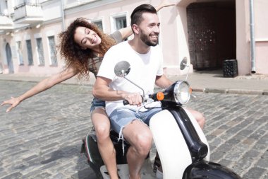 mutlu genç bir çift bir scooter üzerinde eğleniyor