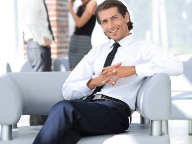 Office sandalyede oturan işadamı gülümseyen