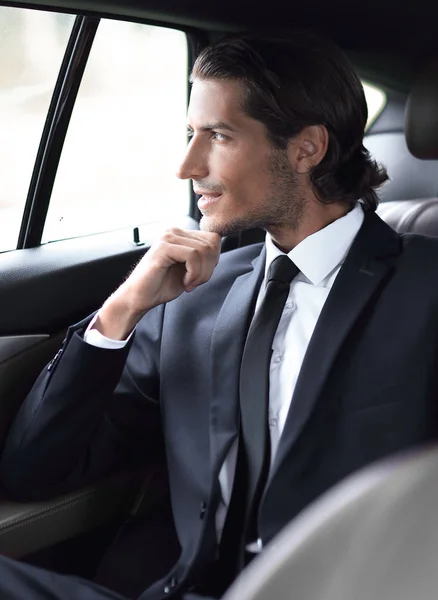Successful man sitting in the back seat of a car — Stock Photo, Image