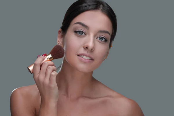 Primer plano de una hermosa mujer con un cepillo de maquillaje — Foto de Stock