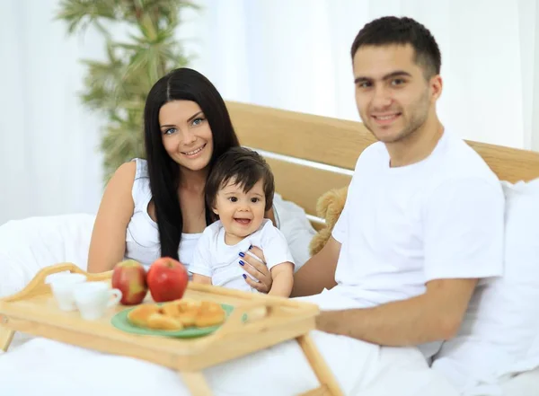 Familia desayunando en la cama en casa — Foto de Stock