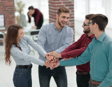 Bir grup insan, ortaklık takım çalışması için el ele tutuşuyor..