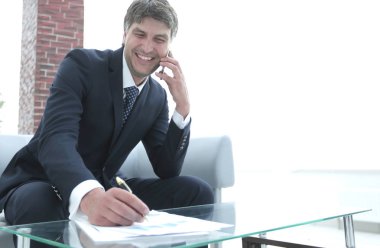 İş yerinde akıllı telefonu olan bir iş adamı.