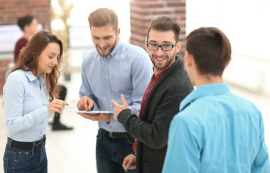 Tablet bilgisayarlı iş ekibi ofiste tartışıyor