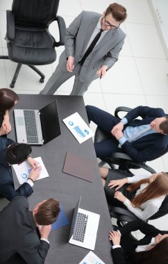 Proje Yöneticisi, iş ekibiyle bir brifing veriyor.