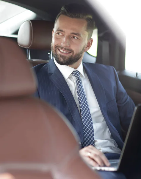 Primer plano de un exitoso hombre de negocios sentado en un coche — Foto de Stock