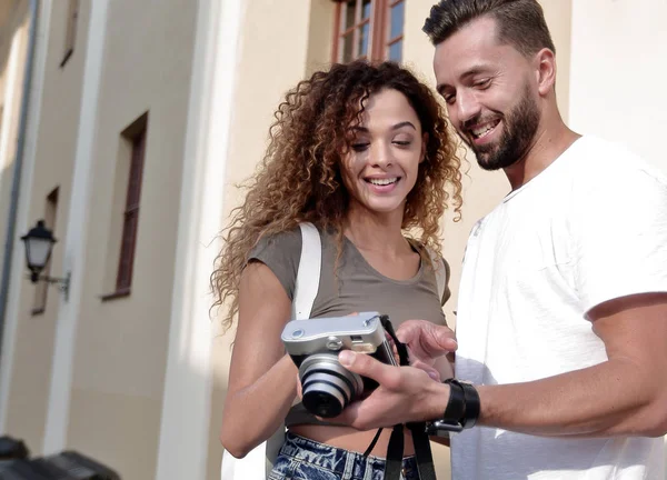Fotoğraflara bakarak yürüyen genç arkadaşların portresi