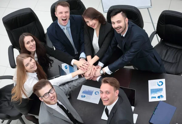Equipe de negócios com as mãos apertadas juntas na mesa — Fotografia de Stock