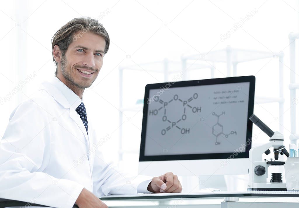 Portrait of a male scientist with a monitor looking at the camer