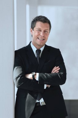 office penceresinde yakınındaki ayakta ciddi iş adamı.