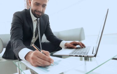 iş grafikleri ile bir dizüstü bilgisayarda çalışan Finans Yöneticisi