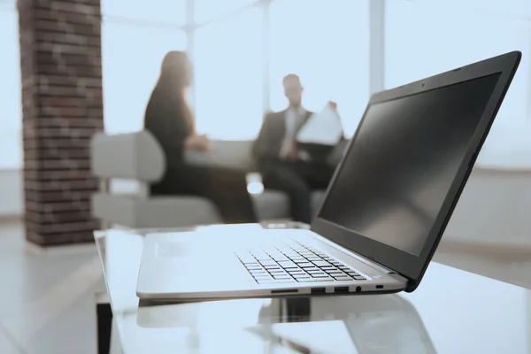 Fokusera på laptop på bordet. Suddiga människor på bakgrund. — Stockfoto