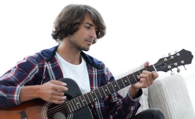 Yakışıklı adam evde kanepede gitar çalmaya