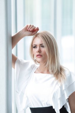 ofis penceresinde yanında oturan modern iş kadın.