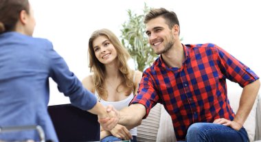 kadın psikolog müşteri aile oturum başlangıcından önce selamlıyor..