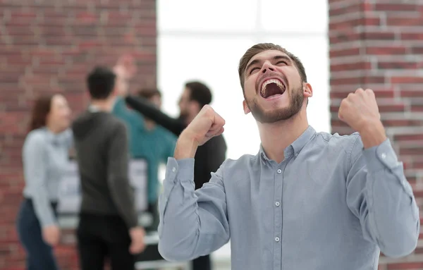 Hombre de negocios guapo celebrando la victoria gritando felizmente en th — Foto de Stock