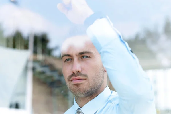 Vue de derrière glass.businessman regardant par la fenêtre du bureau . — Photo