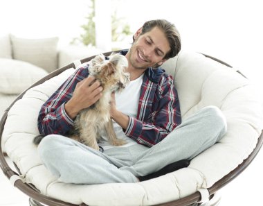 yakışıklı olan büyük bir koltukta oturan bir köpekle.