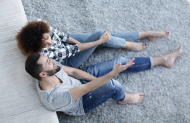 yeni bir oturma odasında bir halı üzerinde oturan yeni evli çift