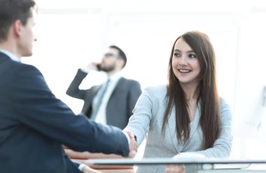 İş kadını iş ortağıyla tokalaşıyor..