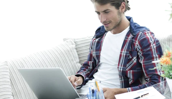 Überraschter junger Mann arbeitet von zu Hause aus mit Laptop. — Stockfoto
