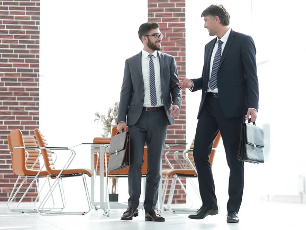 Zwei Geschäftsleute laufen in modernem Bürogebäude mit — Stockfoto