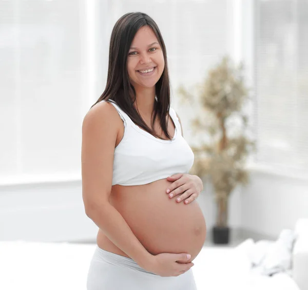 Portrait of young pregnant woman on a light background. Royalty Free Stock Images