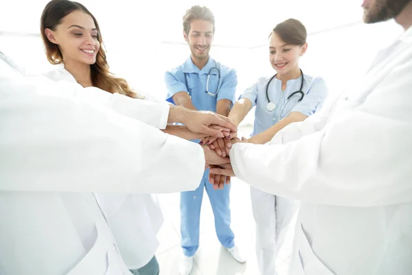 Médicos y enfermeras en un equipo médico apilándose las manos —  Fotos de Stock