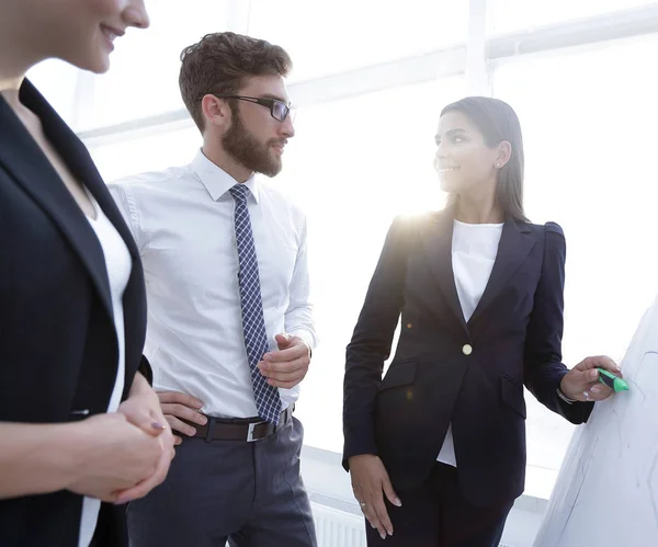 Zakenvrouw aanwijsapparaat horizontale liniaal naar de flipboard op presentatie in office — Stockfoto