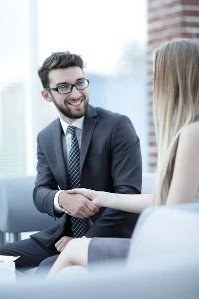 Primer plano de un gerente le da la mano a un cliente regular . — Foto de Stock