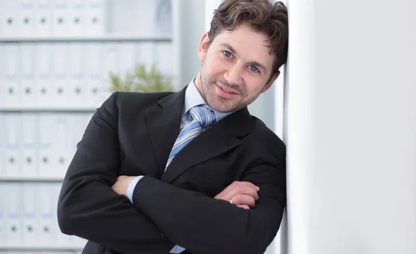 Closeup.handsome hombre de negocios de pie en el fondo de la oficina — Foto de Stock