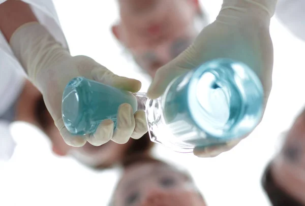 La imagen está borrosa. vasos de precipitados en la mano, y científicos — Foto de Stock