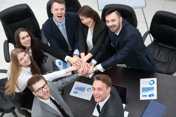 Geschäftsteam mit auf dem Schreibtisch zusammengefalteten Händen — Stockfoto