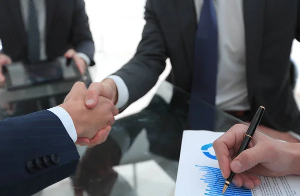 デスクでの金融パートナーの握手 — ストック写真