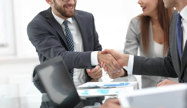 Handshake handlowych partnerów na biurku — Zdjęcie stockowe