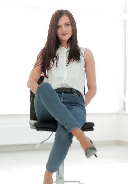 Jonge succesvolle vrouw zitten in een stoel — Stockfoto