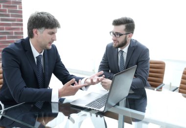 iki işadamı görevleri Office masada oturan tartışıyor.