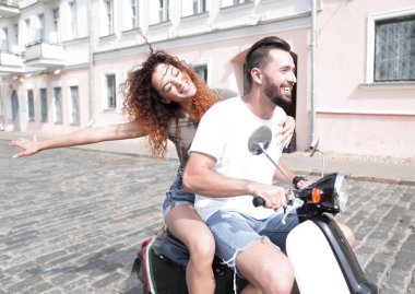 mutlu genç bir çift bir scooter üzerinde eğleniyor