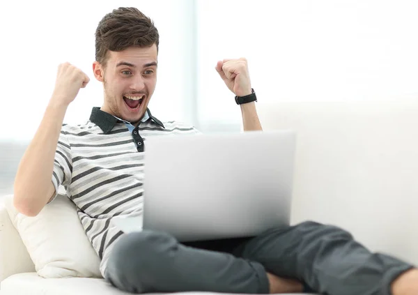 Szczęśliwy człowiek z laptopa siedząc na kanapie — Zdjęcie stockowe
