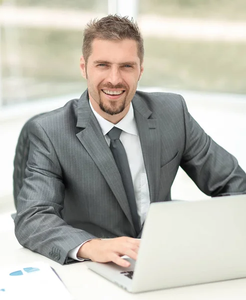 Primo piano. Uomo d'affari sorridente che lavora con il computer portatile — Foto Stock