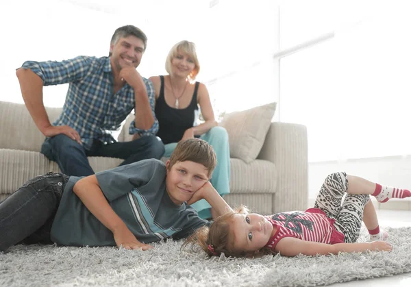 Portret van kinderen terwijl de ouders zitten op de Bank in levende roo — Stockfoto