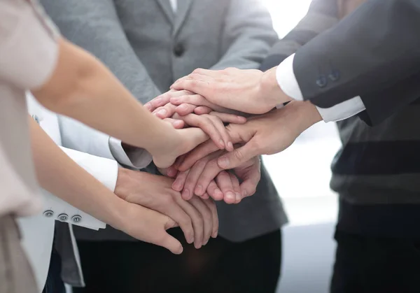 Collega's met hun handen elkaar gestapeld — Stockfoto