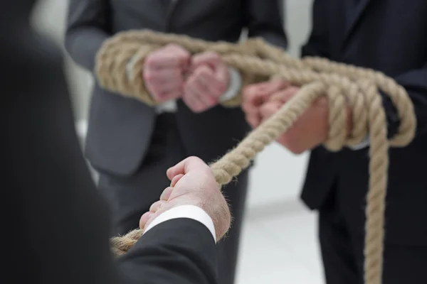 Close up.businessman pulls related employees — Stock Photo, Image