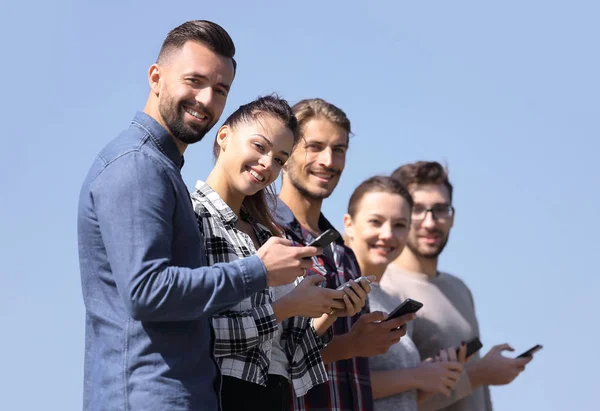 Gruppe junger Menschen mit modernen Smartphones. — Stockfoto