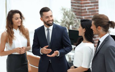 Gülümseyen iş adamları konuşuyor, ofiste duruyorlar.