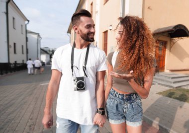 Bir çift şehrin sokaklarında yürüyor ve eğleniyor.