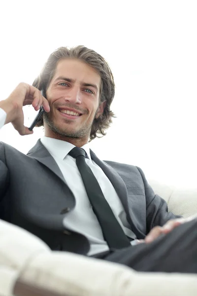 Hombre de negocios hablando en un teléfono inteligente mientras está sentado en una silla cómoda . —  Fotos de Stock