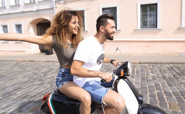 Feliz jovem casal se divertindo em uma scooter — Fotografia de Stock