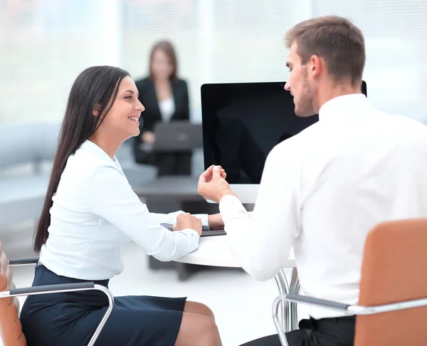 Dos empleados exitosos hablando sentados detrás de un escritorio — Foto de Stock